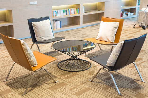 Home library with bookshelves with chairs near it. 