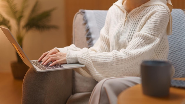 Home lifestyle concept Young woman typing data and working on laptop at late night winter