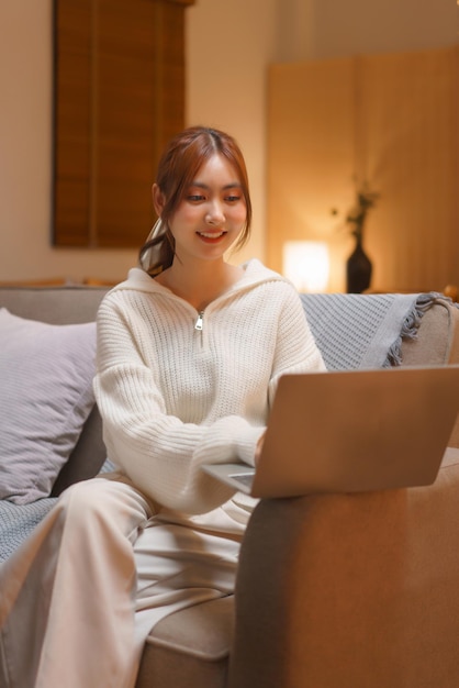 Home lifestyle concept Young woman typing data and working on laptop at late night winter