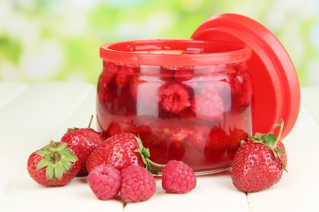 Home made berry jam on wooden table on bright background