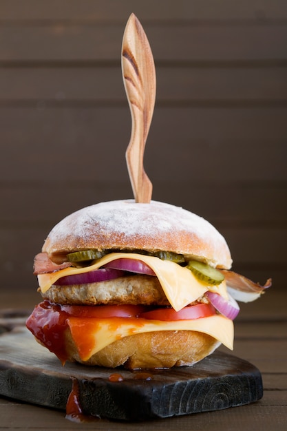 Home made big Burger on wooden background.