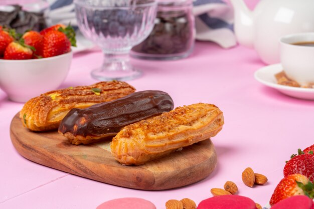 Home made cake eclairs on pink table