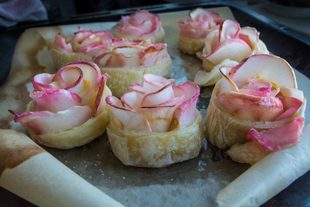 Home-made pastries. Apple’s Roses from puff pastry on a baking sheet. 