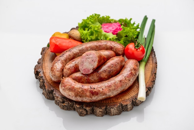 Home-made sausage with vegetables on a wooden board