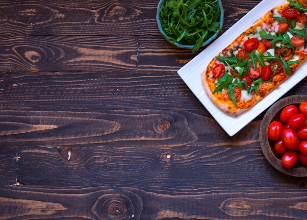 Home maid fresh pizza with tomatoes, rucola and mozzarell