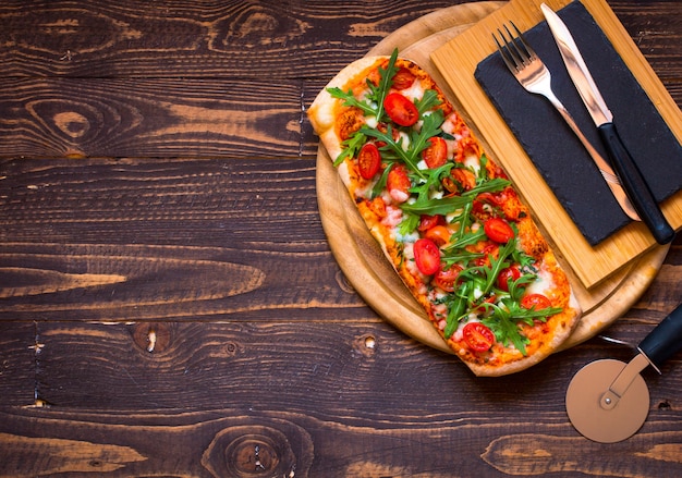 Home maid fresh pizza with tomatoes, rucola and mozzarella