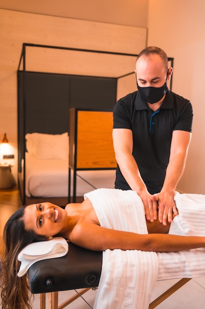 Home massage a young man performing a massage at the client's home