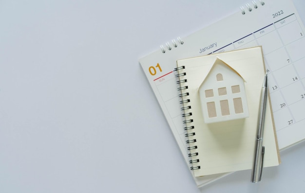 Home model and on calendar over white color background with space for home loan