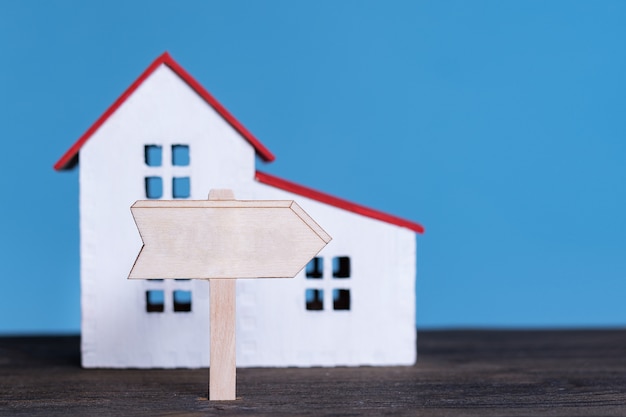 Modello di casa con cartello in legno. comprare casa concetto.