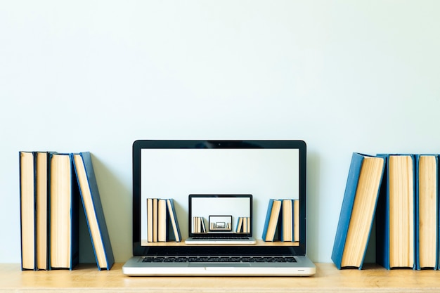 Home office desk table background. Empty laptop screen pc on the wooden table with books for work or study. High quality photo