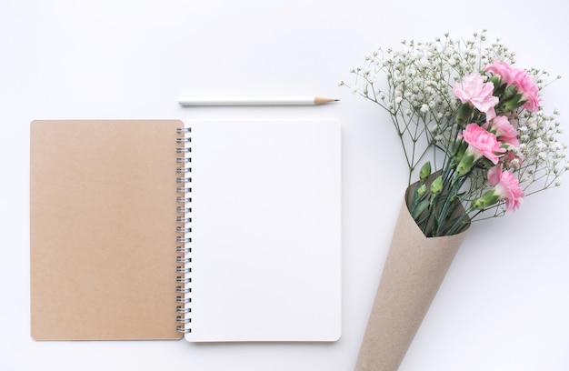 Home office desk table with notepad, flower on white background.