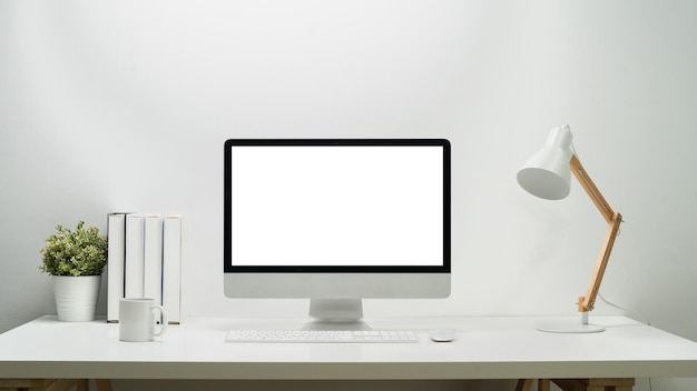 Home office desk with blank screen computer houseplant and books Empty screen for montage your graphic display