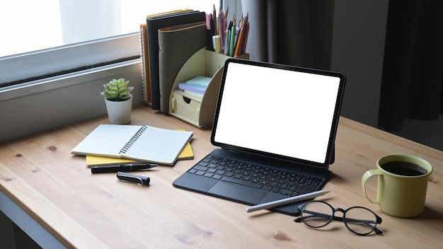 Home office desk with computer tablet glasses coffee cup and stationery