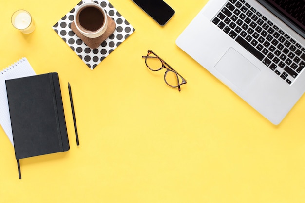 Home office desk. Workspace with computer on yellow background. Flat lay, top view. Fashion blog look. Add your text.