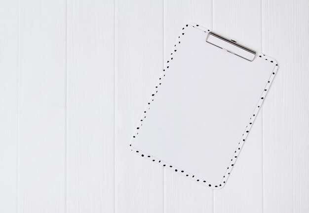 Home office white wooden table with clipboard.