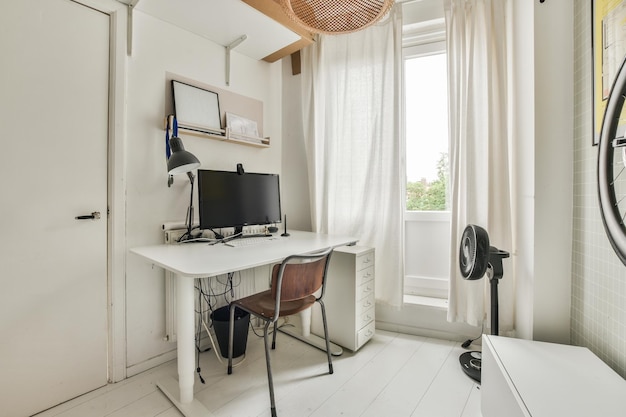 A home office with a white desk and a computer