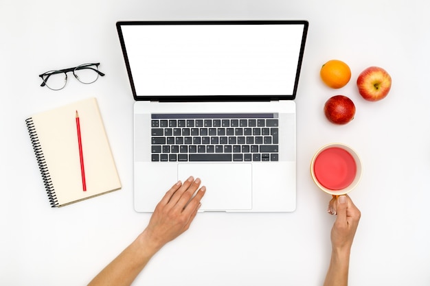 Home office workspace mockup. Laptop with blank screen, hands and accessories on white