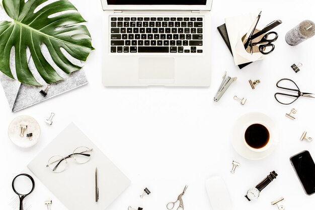 Foto mockup dell'area di lavoro dell'ufficio domestico con notebook e accessori per appunti monstera con foglie tropicali