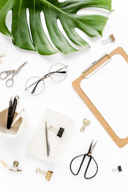 Home office workspace mockup with tropical leaves monstera clipboard and accessories on white backgr