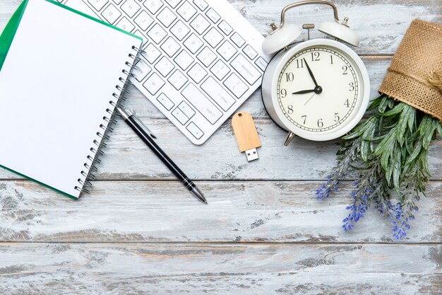 Home office workspace with computer keyboard and green plant on wooden background