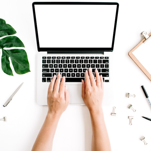 Home office workspace with hands working on laptop keyboard