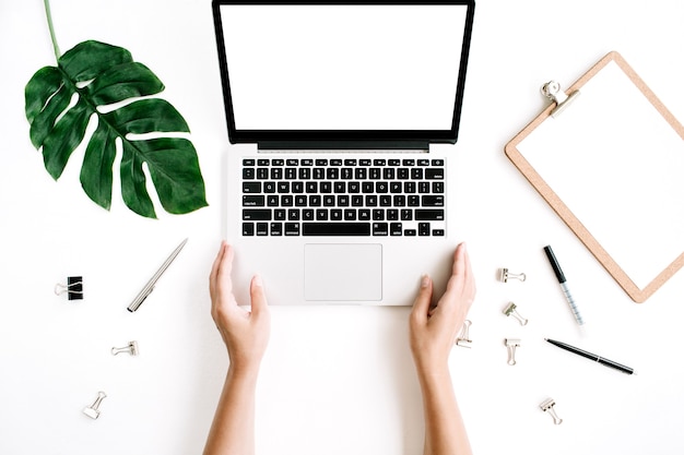 Home office workspace with hands working on laptop keyboard