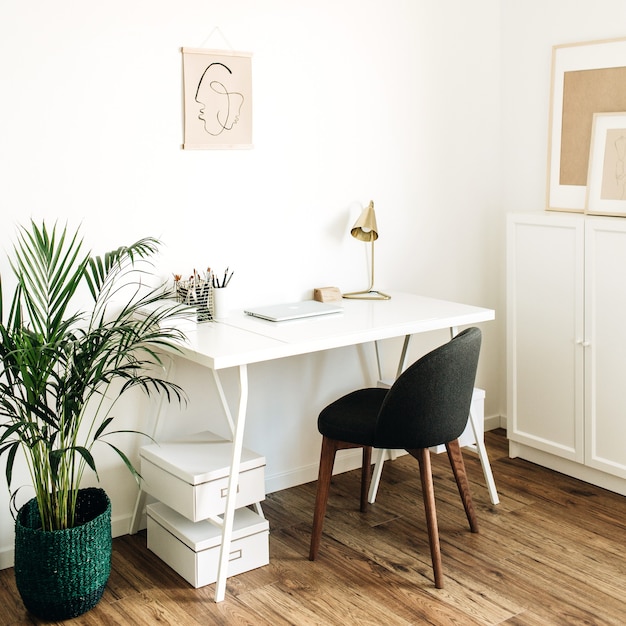 Home office workspace with table, chair, palm