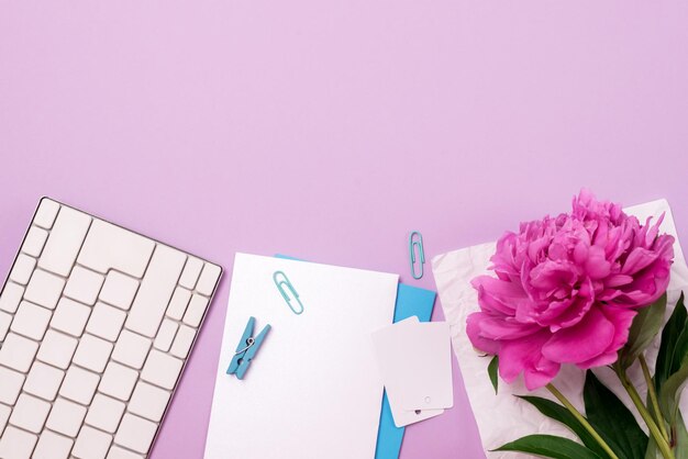 Photo home office workspace with white keyboard peony flower white blank background feminine workspace