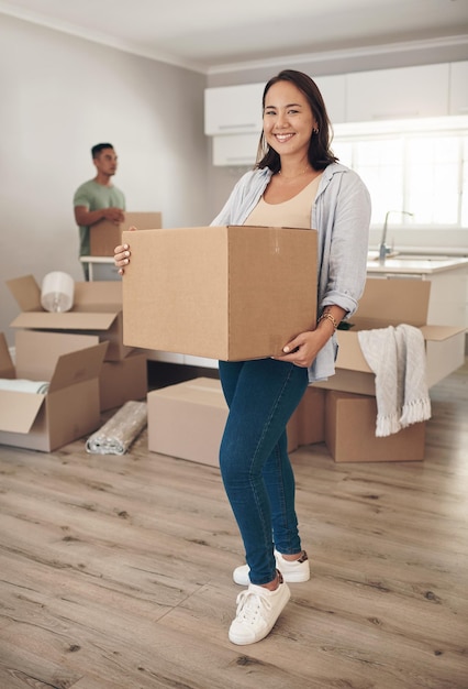 Home ownership is a feeling that makes lifes daily grind worth facing Shot of a woman holding a box while moving into her new home with her partner