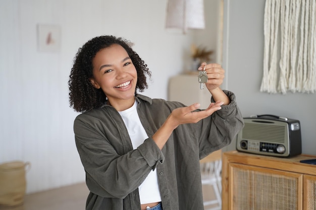 Photo home ownership young african american girl is holding and showing key from new home