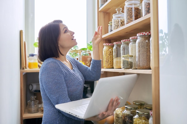 Home pantry kitchen interior woman with laptop recording vlog storage organization