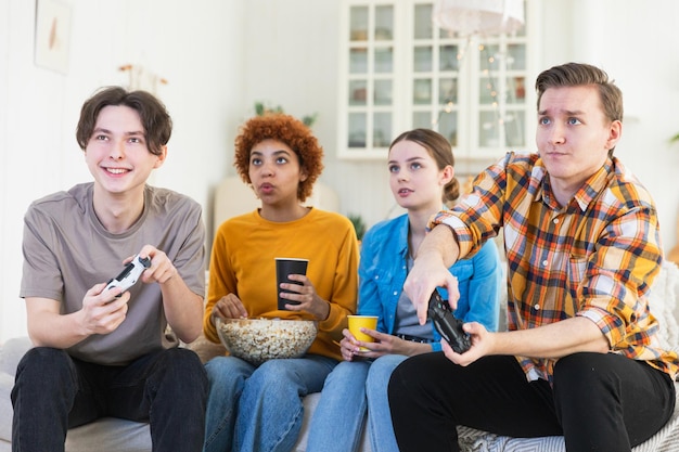 家でビデオゲームをしている友達の楽しいグループ ホームパーティで楽しい多様なグループの友達が