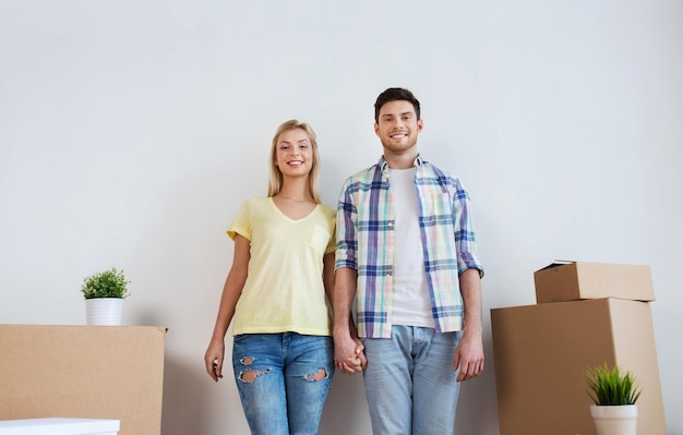 home, people, repair and real estate concept - smiling couple with big cardboard boxes moving to new place