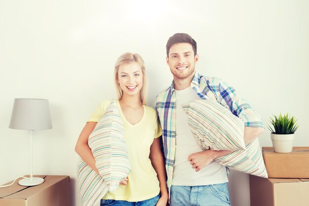 Photo home people repair and real estate concept smiling couple with big cardboard boxes and stuff moving to new place