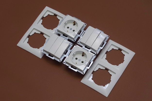 Home plastic sockets and switches for electricity on a brown background