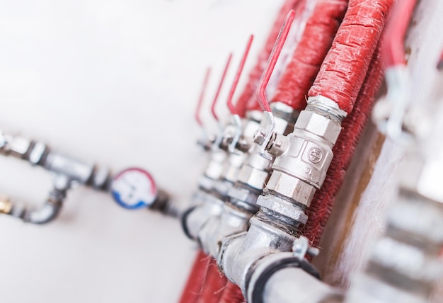 Photo home plumbing system closeup photo red isolated pipes with ball valves residential water supply system