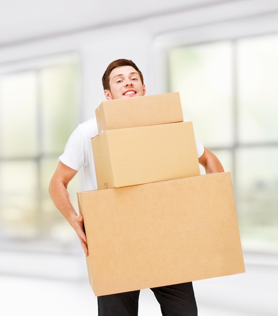 Photo home, postal service and delivery - young man carrying carton boxes