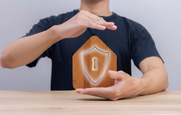 Foto concetto di assicurazione di assicurazione di protezione domestica tenere in mano una mini casa di legno