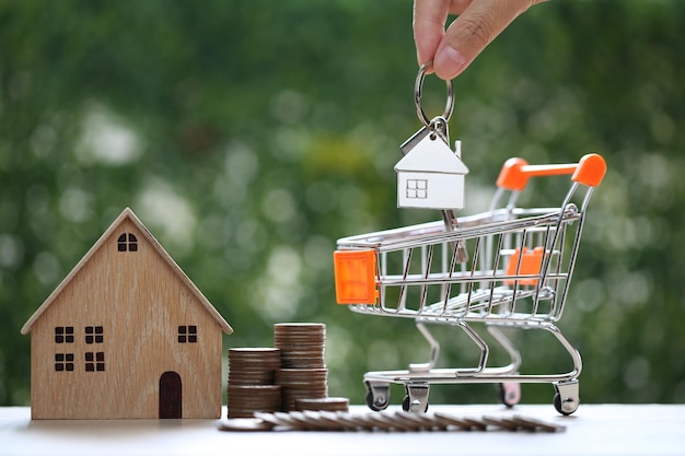 Photo home for salemodel house and miniature shopping cart on natural green background business investment and real estate concept