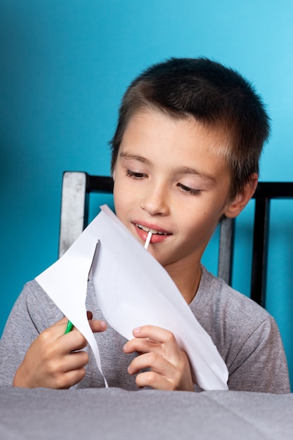 Home schooling. Boy does homework, paper cut