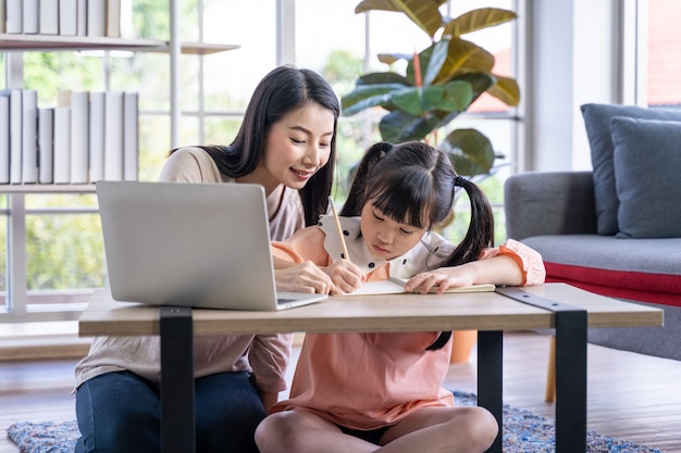 Photo home schooling learning at home during virus pandemic asian woman with her daughter