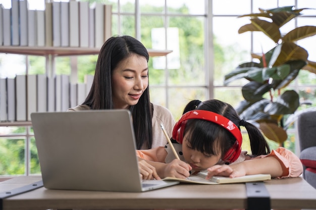 Photo home schooling learning at home during virus pandemic asian woman with her daughter