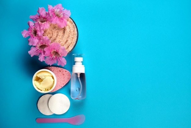 Foto home spa-concept potje crèmeroze himalayazout gezichtstonic op een lichtblauwe achtergrond plat lag kopieer ruimte