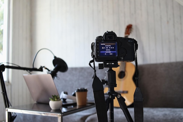 Home studio audio podcast interieur. Microfoon, laptop en koptelefoon op tafel en gitaar