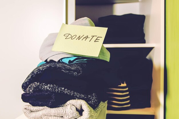 Home wardrobe with different clothes sorted for donation.