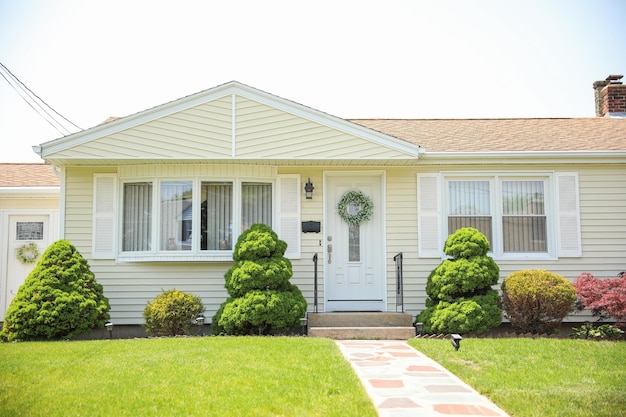 A home with a front door and a green wreath on the front.