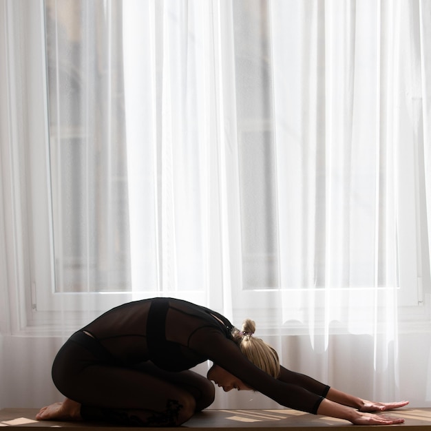 Allenamento a casa donna che fa esercizio di stretching a casa ragazza che fa esercizio di yoga o pilates