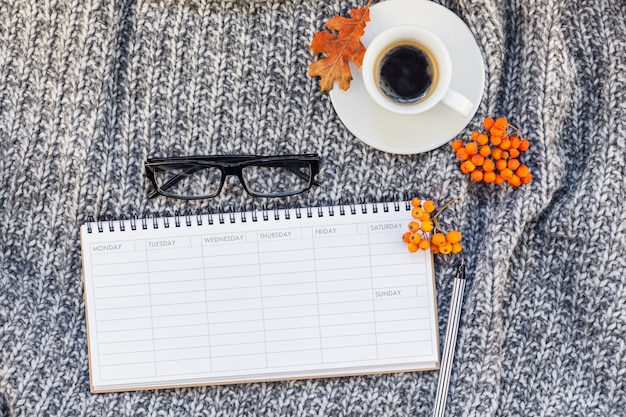 Home workplace with coffee cup on knitted plaid