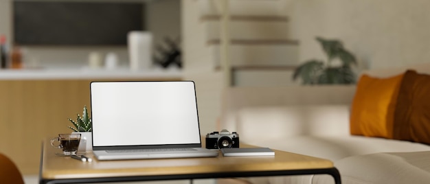 Домашнее рабочее место с ноутбуком на деревянном журнальном столике в современной удобной гостиной