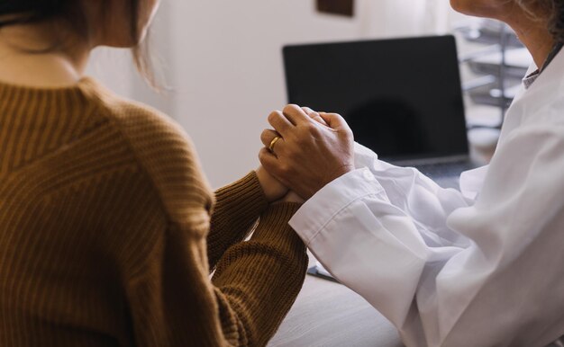 Foto assistenza domiciliare servizio infermieristico e anziani cardiologia assistenza sanitaria primo piano di una giovane infermiera medico ispanica controlla il battito cardiaco del paziente uomo caucasico maturo utilizzando lo stetoscopio durante la visita